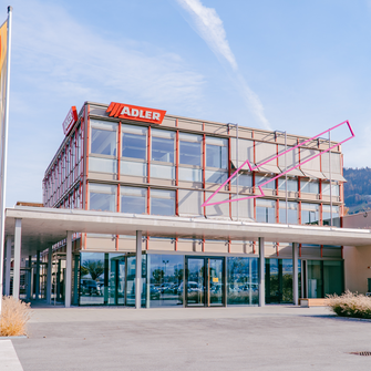 Hier geht’s lang: Der große rosa Pfeil – ein Kunstwerk von Christoph Hinterhuber – weist den Weg in den neu gestalteten ADLER-Empfangsbereich.  | © ADLER