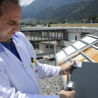 Versuch bei prallem Sonnenschein am ADLER-Dach: Durch die Ausrüstung mit dem Anti-Heat-Zusatz weist die Musterfläche eine deutlich niedrigere Oberflächen-temperatur auf.  | © ADLER