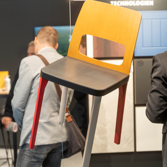 Hingucker am ADLER-Stand: Der mit verschiedenen ADLER-Beizen farbenfroh gestaltete Sessel.  | © ADLER