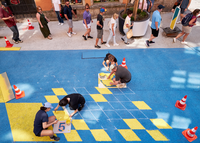 Vom grauen Asphalt zum kunterbunten Spielplatz: Das Tirolack-Malerteam bei der Arbeit. | © © Randall Media Factory / Eduardo Espinosa