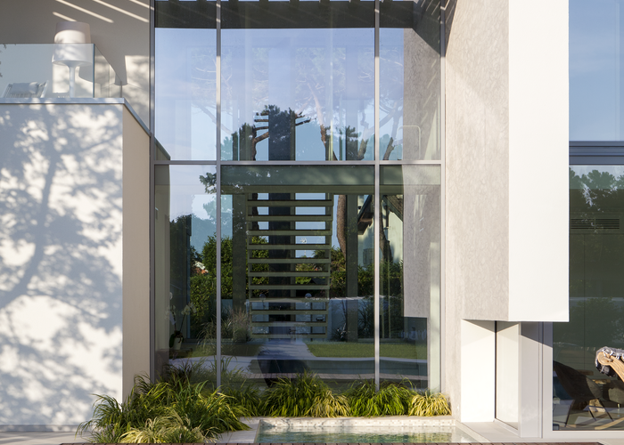 La porta monumentale permette il passaggio della luce da una parte all'altra della villa | © Ikebeo, per Oikos Venezia srl