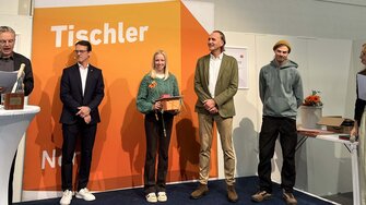 … Leonie Feuerstack (3.v.li.) und ihren Ausbildner Fabian Kath auf die Bühne (2.v.re.)  | © Tischler Nord