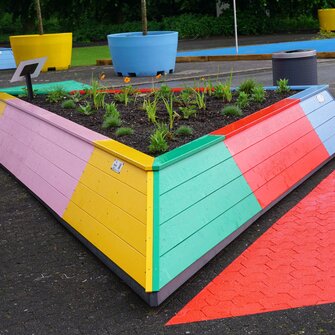 Die Dreieck-Hochbeete erstrahlen dank Lignovit Terra-Color von ADLER in den Logo-Farben der Landesgartenschau Neuss.  | © August Bruns GmbH & Co. KG